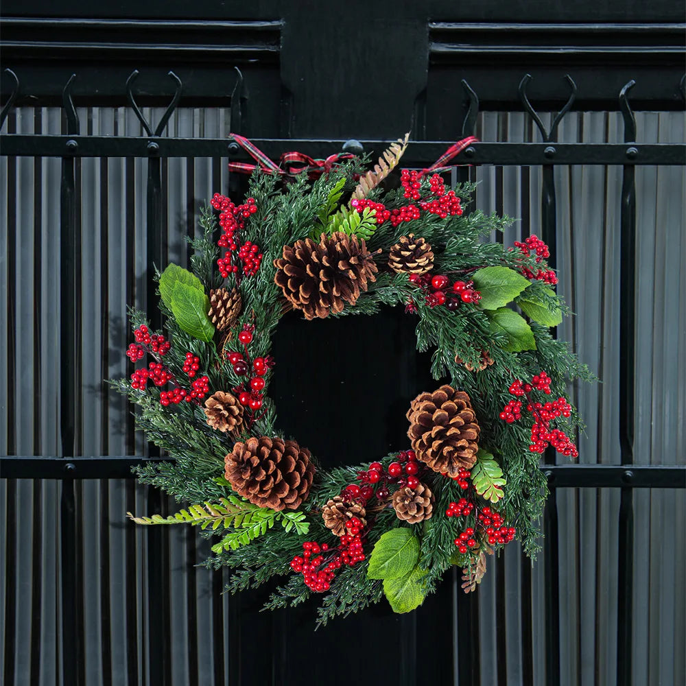 Detail van cipresgroene takken en rode bessen op de kerstkrans