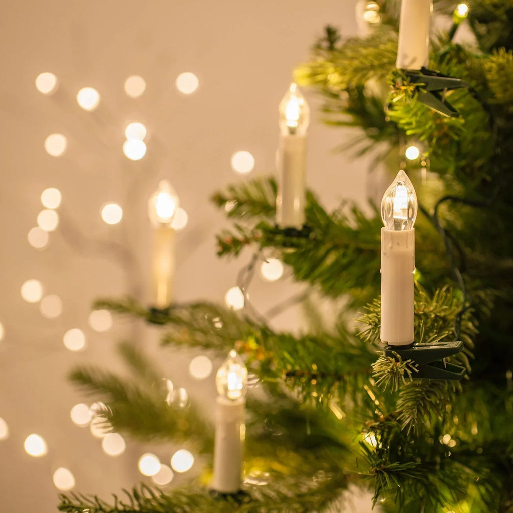 Detail van warmwitte leds tussen de takken van een kerstboom